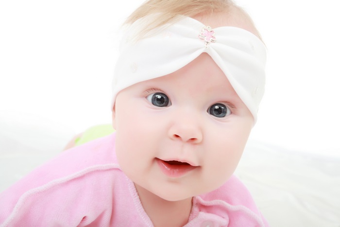 Cute baby with white headband and pink outfit