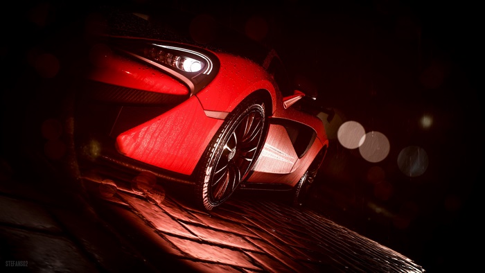 Red McLaren sports car in the rain at night
