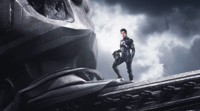 Man in Power Rangers suit standing on giant robot