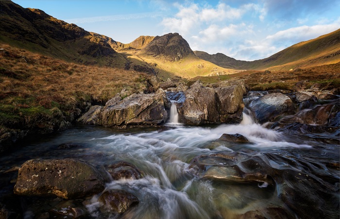 Mountain stream with waterfalls and rocky terrain