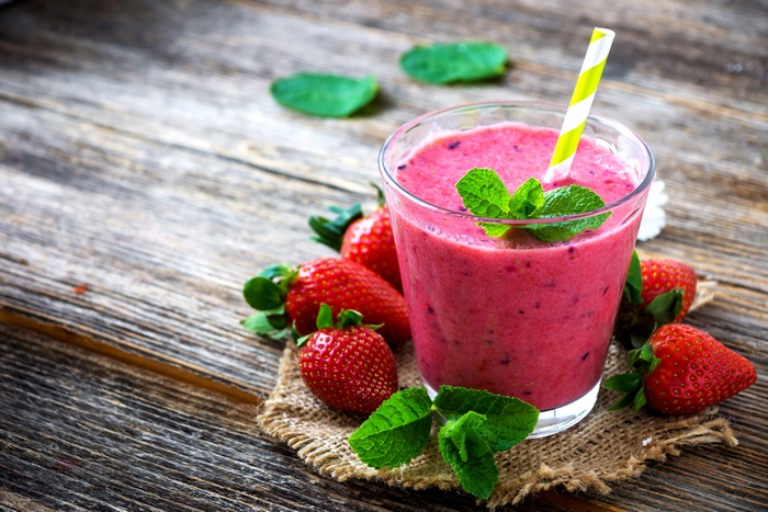 Strawberry smoothie with mint and strawberries on wooden table