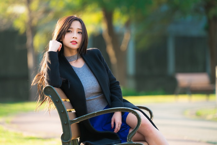 Elegant Asian Woman Sitting on Park Bench in 4K
