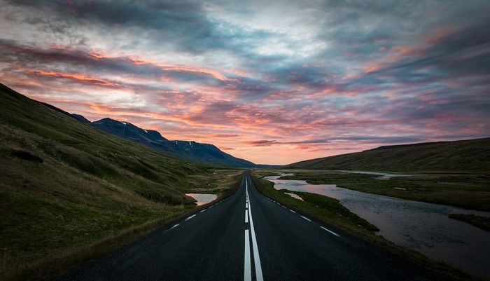 Road through Iceland landscape at sunset