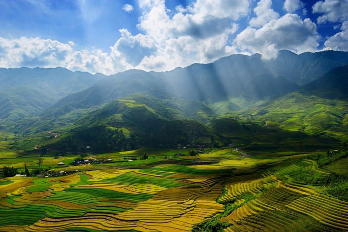 Terraced fields in a mountain valley with sun rays