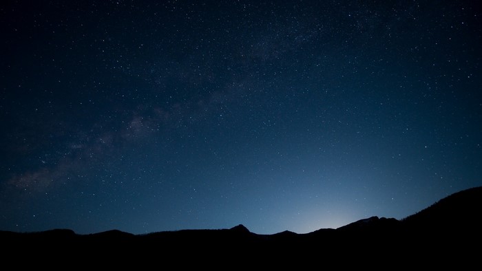 Night sky with Milky Way over silhouetted mountains