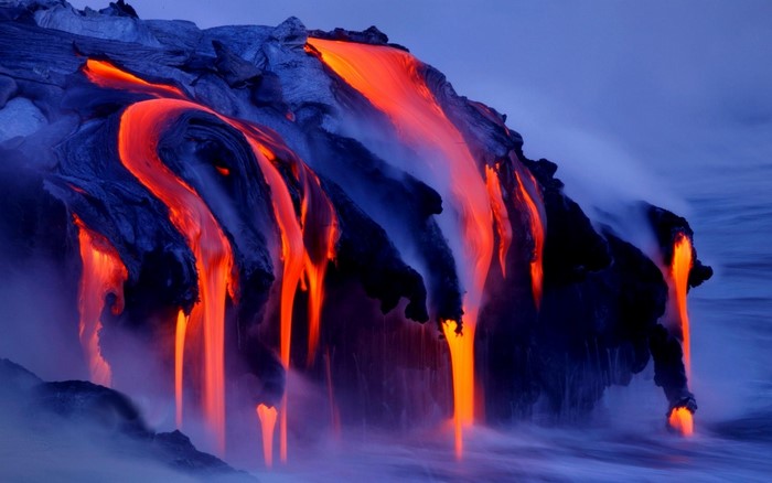 Molten lava flowing into the ocean at dusk