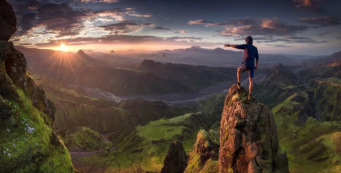 Man on mountain peak at sunrise in Iceland
