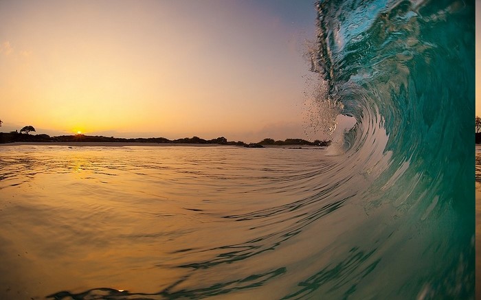 Wave crashing at sunrise on a Hawaiian beach