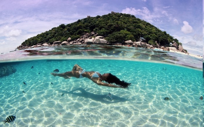 Underwater View of Woman Floating Near Tropical Island in Thailand
