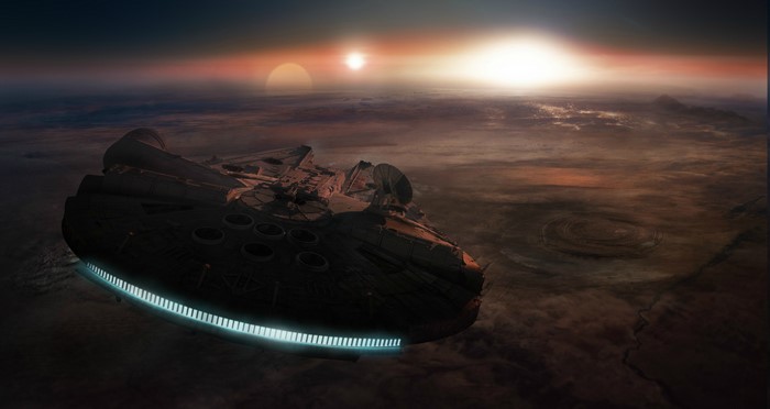 Millennium Falcon flying over a desert planet at sunset