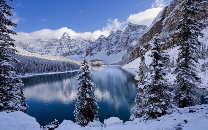 Winter scene at Moraine Lake with snow-covered mountains and trees