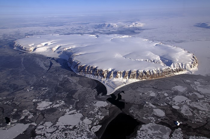 Aerial view of a snow-covered island with glaciers and ice floes