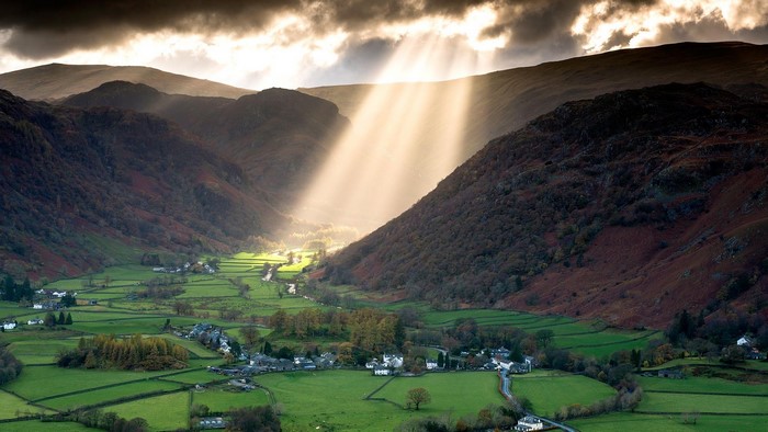 Sun rays over a valley village in England
