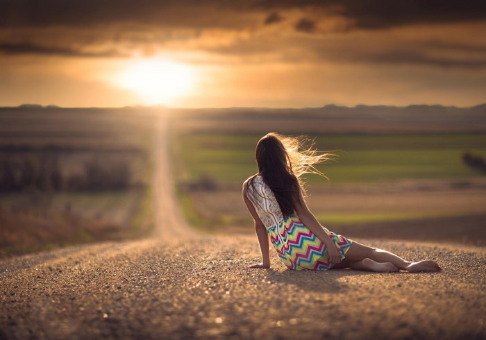 Woman Sitting on Rural Road at Sunset in Nebraska