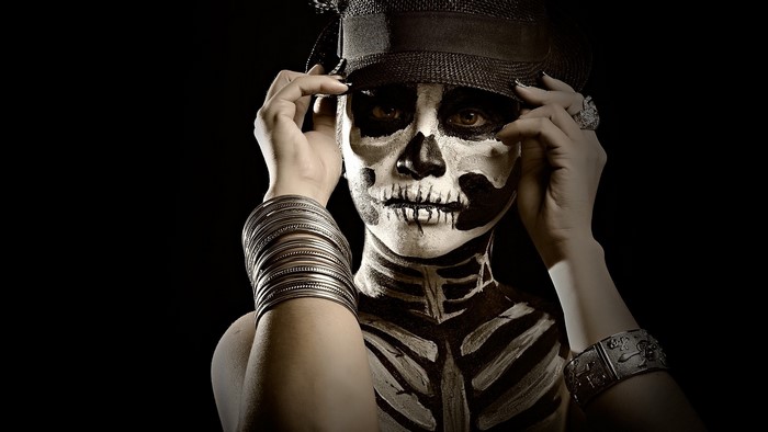 Woman with skeleton face paint and hat