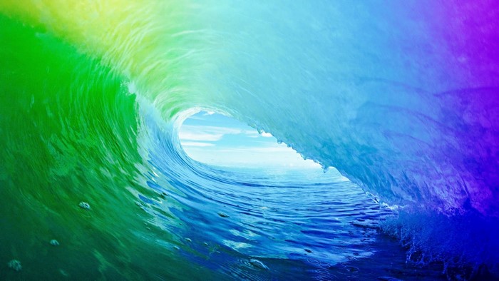 Colorful wave breaking with ocean and sky visible