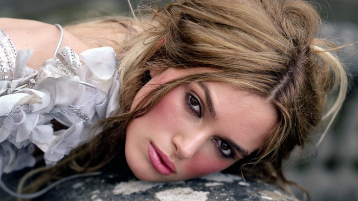 Keira Knightley lying on a rock outdoors