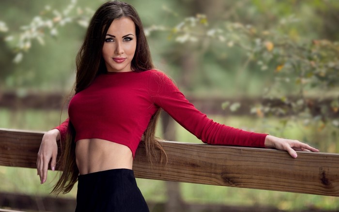 Woman in red crop top and black skirt outdoors