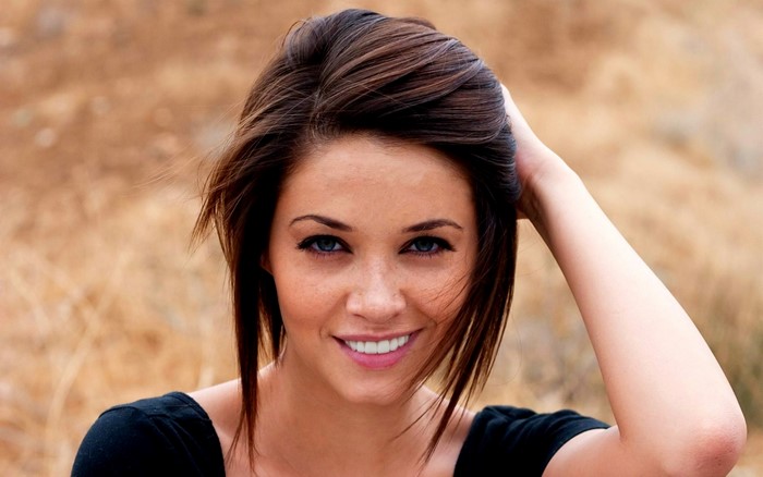 Woman with brown hair and blue eyes smiling
