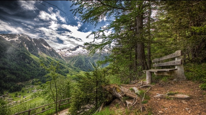 Bench overlooking a mountain valley with snowy peaks