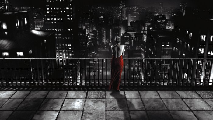 Woman in red dress on balcony overlooking Sin City