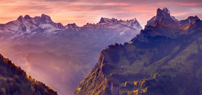 Swiss Alps mountains at sunset with mist and snow