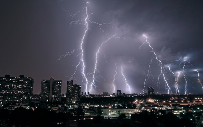 Lightning strikes over a city at night