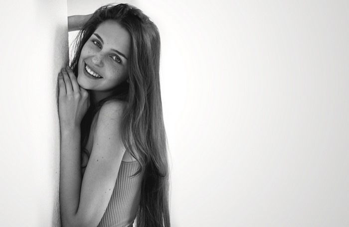 Monochrome portrait of a smiling woman with freckles