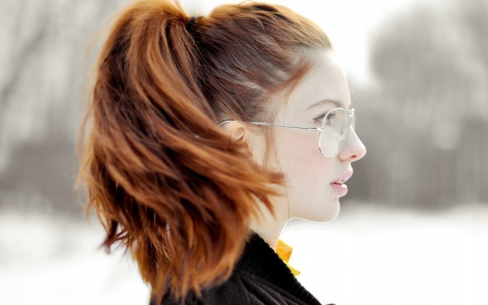 Redhead woman with glasses in profile