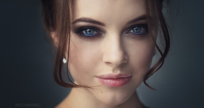 Woman with brunette hair and blue eyes, smoky eye makeup