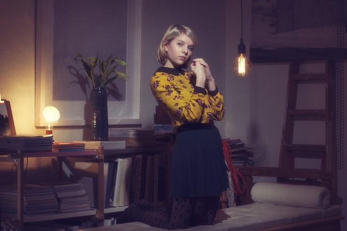 Aurora Aksnes kneeling in a room