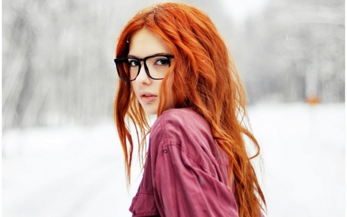 Redhead girl with glasses in the snow