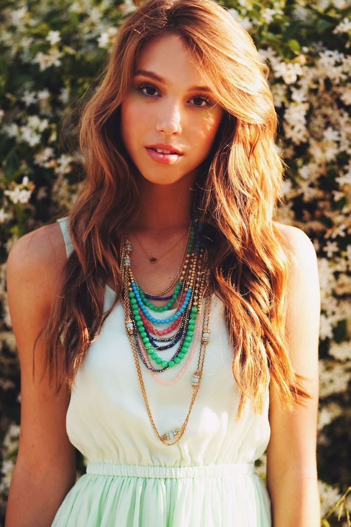 Alexis Ren wearing a mint green dress and layered necklaces
