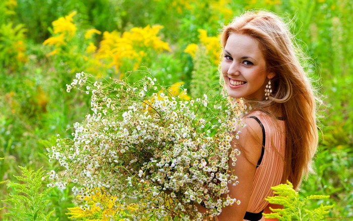 Woman holding a bouquet of flowers in a field