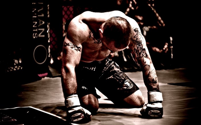 MMA fighter kneeling in the ring