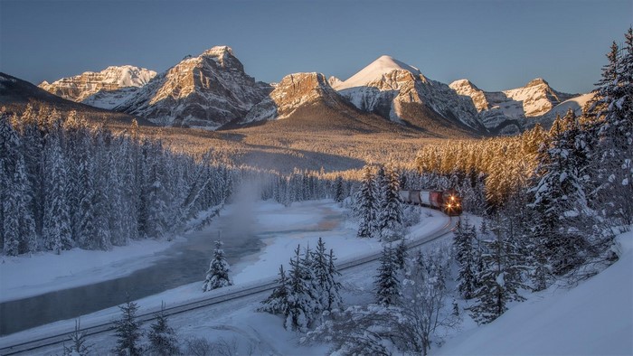Train in snowy Canadian Rockies at dusk