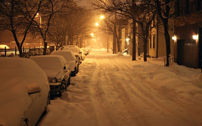 Night street in winter with snow covered cars and street lights