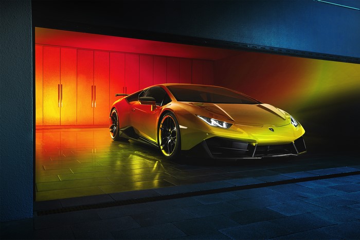 Yellow Lamborghini sports car in a garage with colorful lighting
