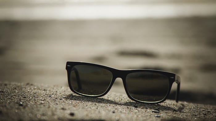 Ray-Ban sunglasses on sand at the beach