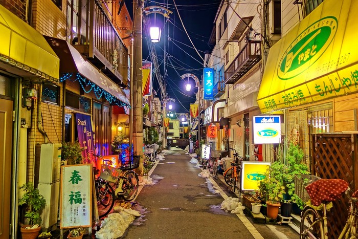 Japanese street at night with illuminated signs and snow