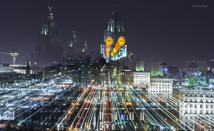 Liverpool night cityscape with light trails and clocks