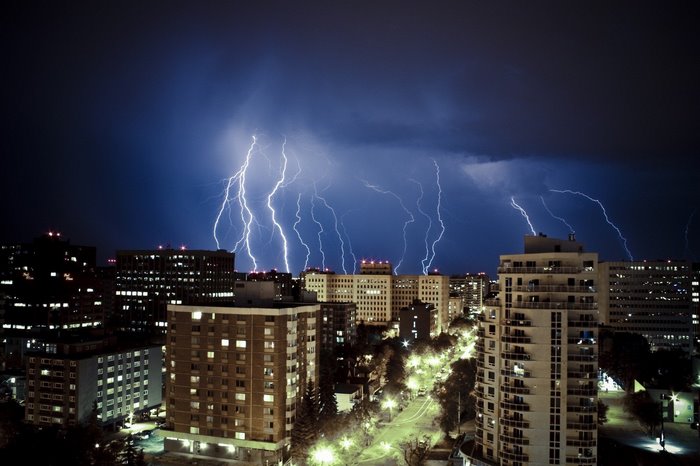 Lightning storm over city buildings at night