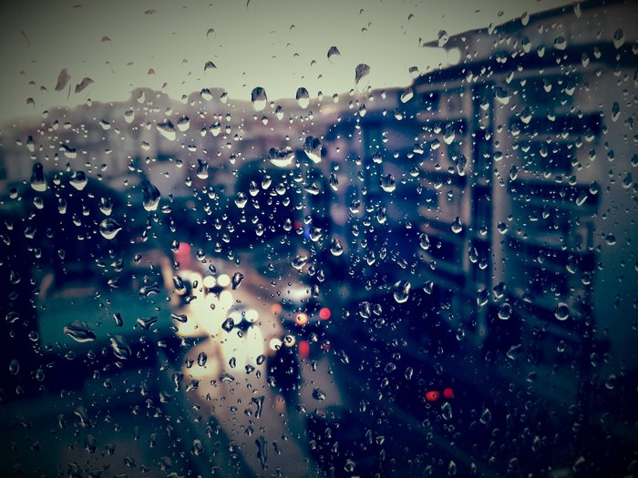 Rainy day view through a window with water drops