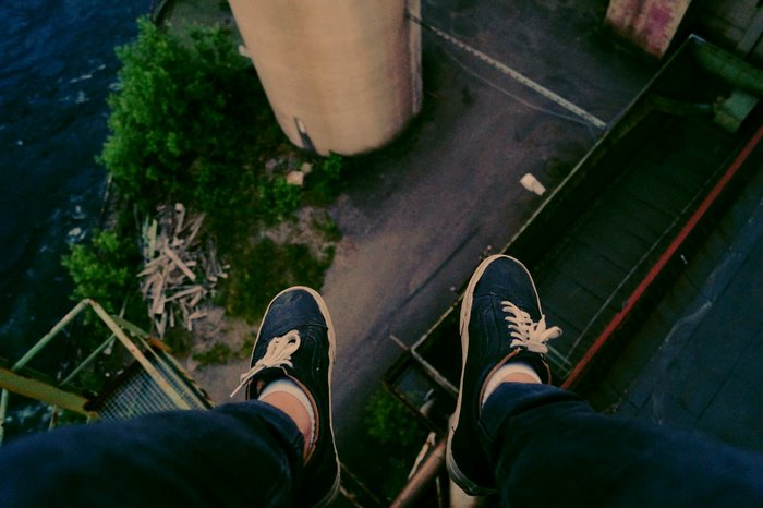 POV of person wearing Vans shoes on factory roof