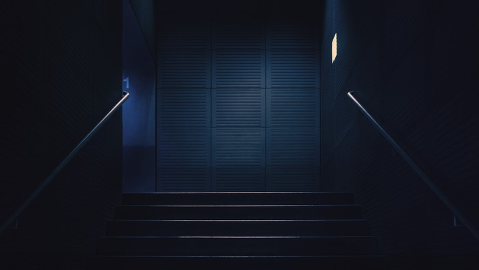 Dark Stairway with Blue Light and Handrails