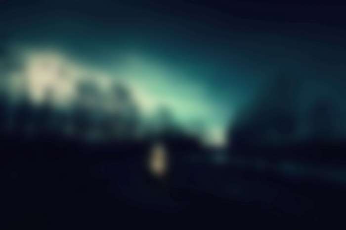 Dark blurred landscape with glowing light
