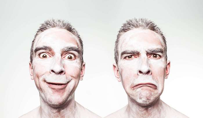 Man with contrasting emotions and white face paint