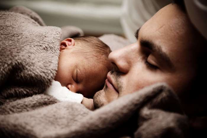 Father and Newborn Baby Sleeping Together