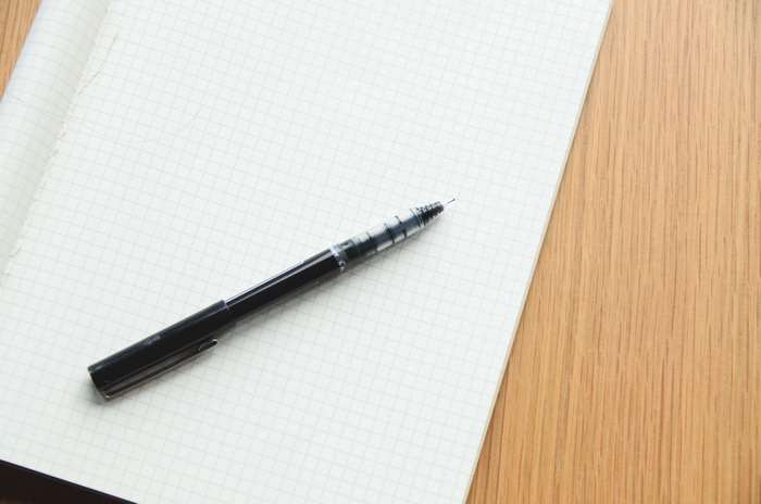Black pen on a grid paper notebook