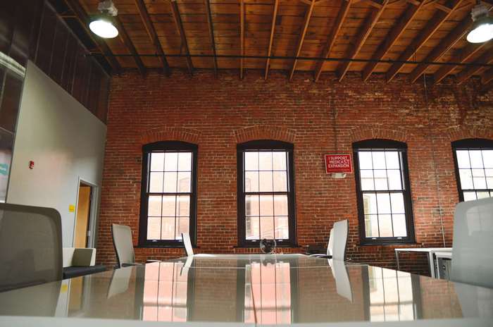Modern office space with brick walls and wooden ceiling